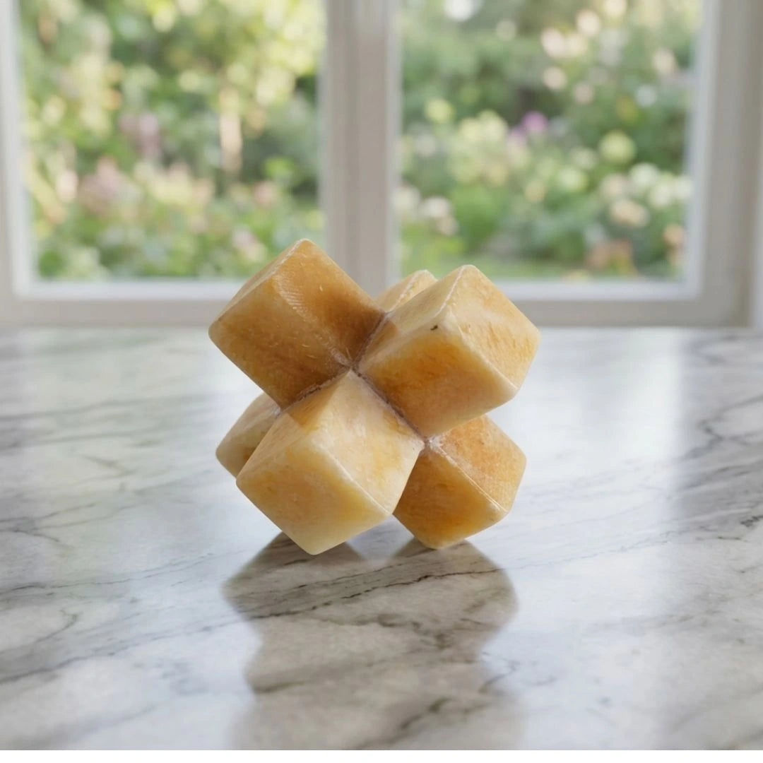 A decorative geometric stone jack sculpture in warm amber tones