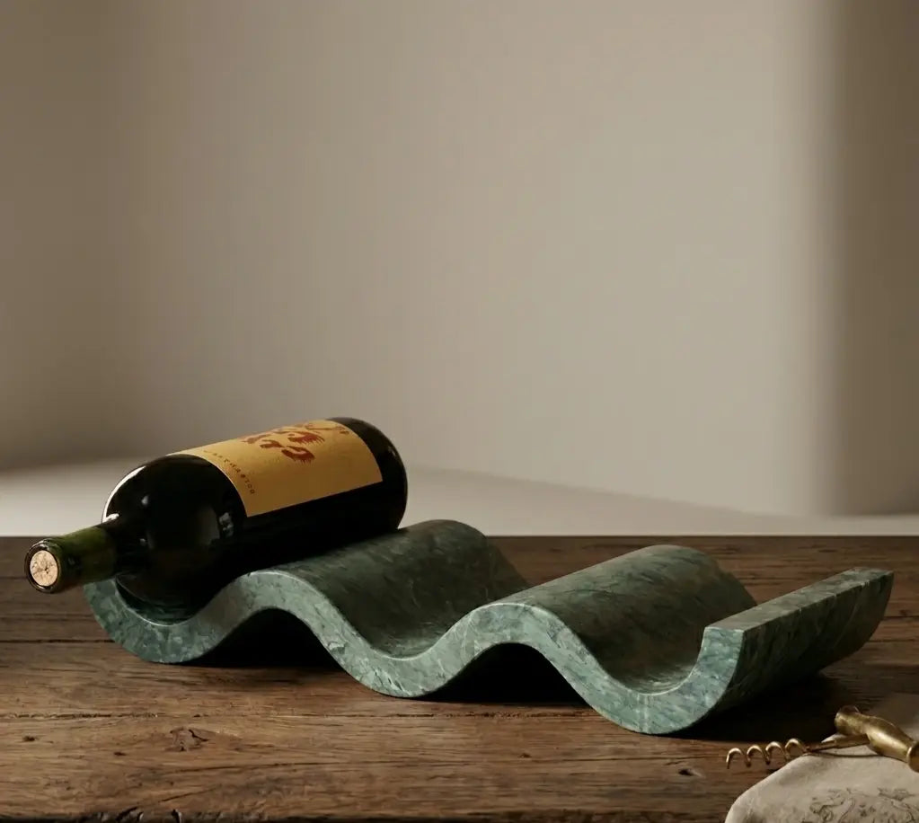 A modern wine display featuring a sculptural marble rack and a single bottle