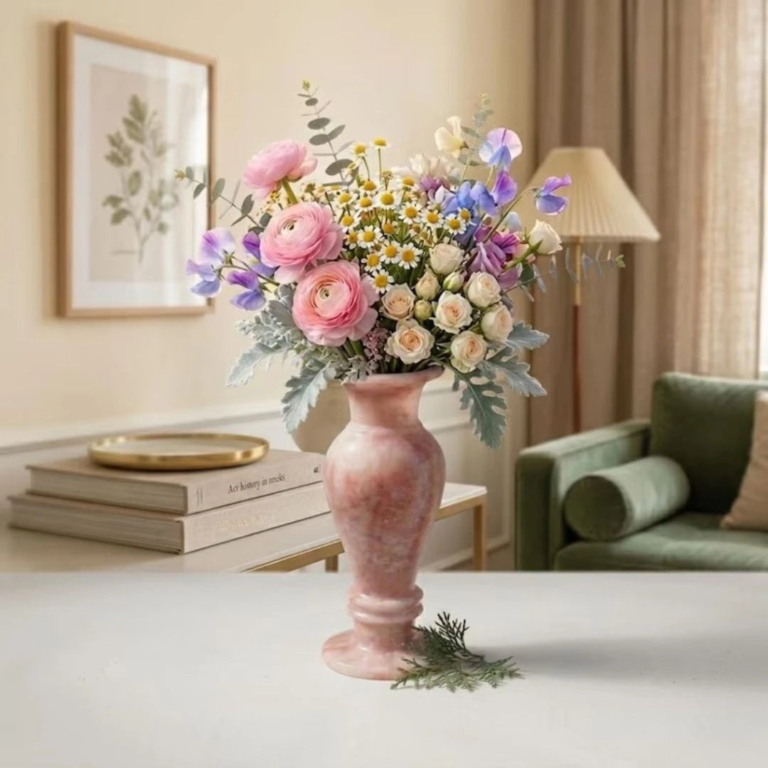 Handcrafted rose-toned marble flower vase displayed with fresh flowers in a modern, light-filled interior.