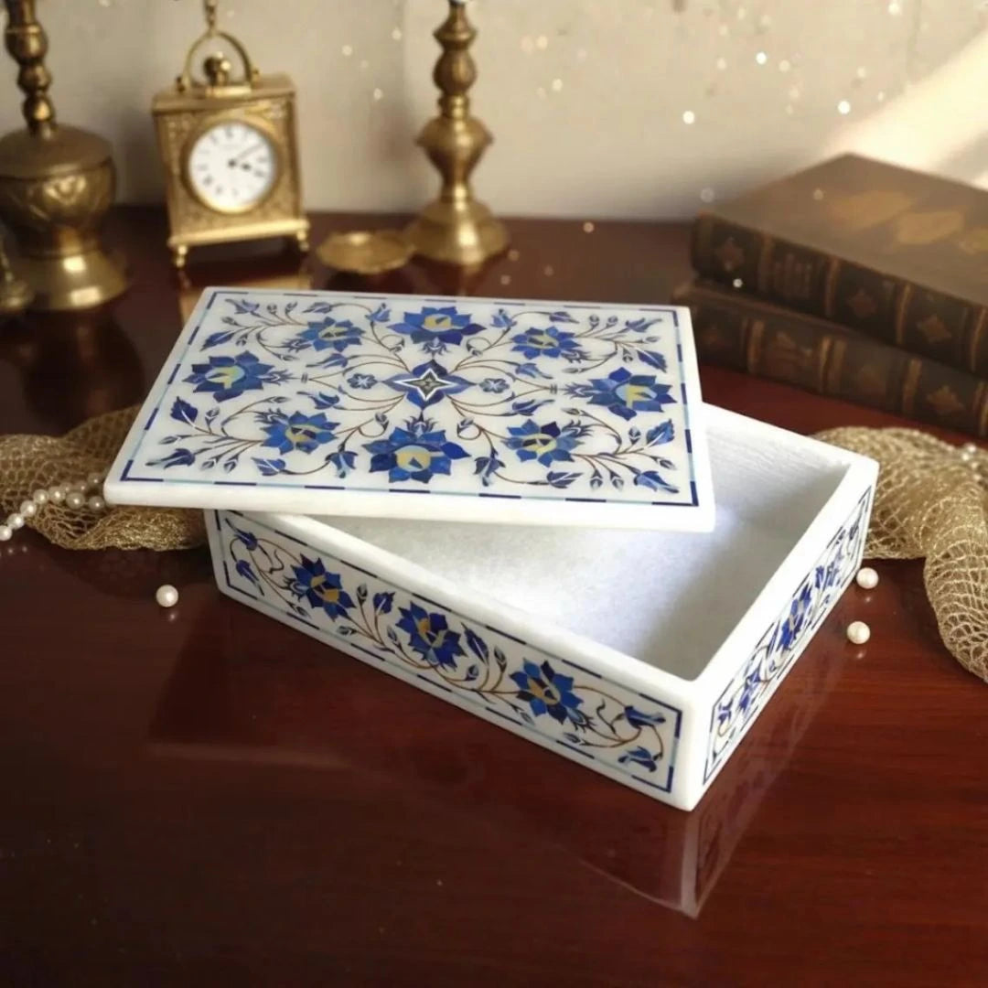 Artisan marble keepsake box with hand-inlaid blue floral motifs and smooth polished finish.