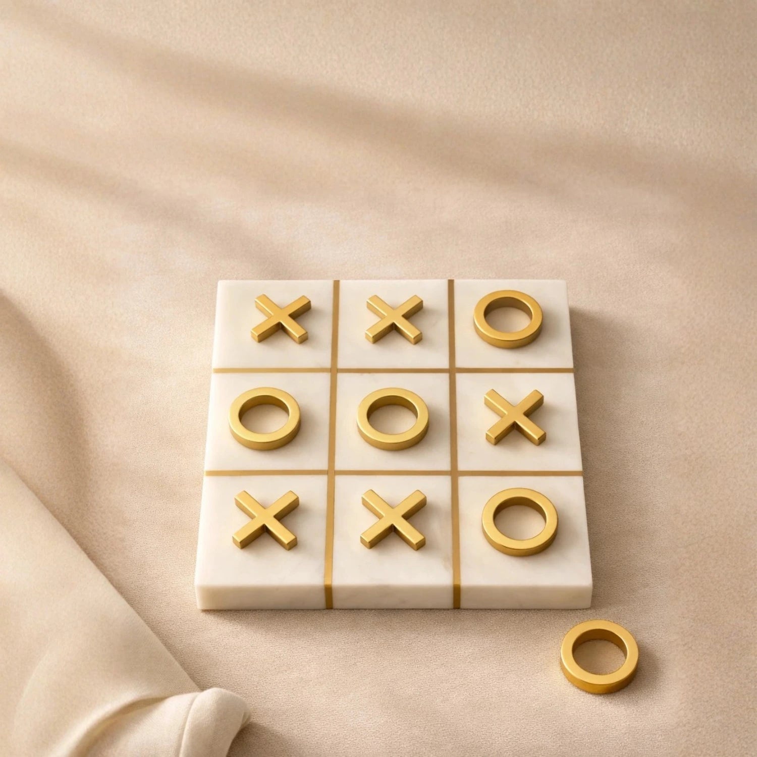 Handcrafted marble tic tac toe board with gold X and O pieces styled as modern coffee table decor
