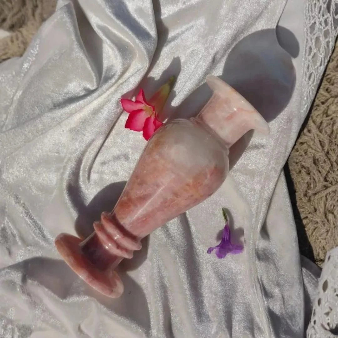 Handcrafted rose-toned marble flower vase displayed with fresh flowers in a modern, light-filled interior.