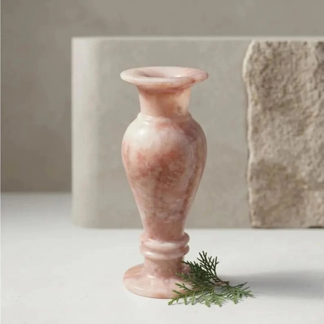 Designer marble vase in soft rose hues, styled with seasonal flowers for timeless luxury interior decor.